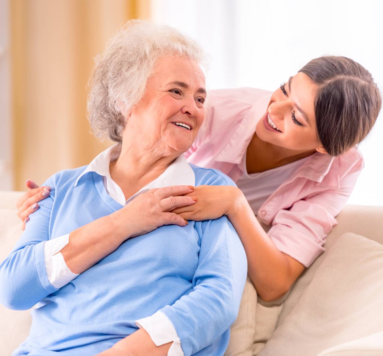 Mujer mayor sonriendo a mujer joven